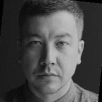 Close up black and white headshot of man staring at the camera