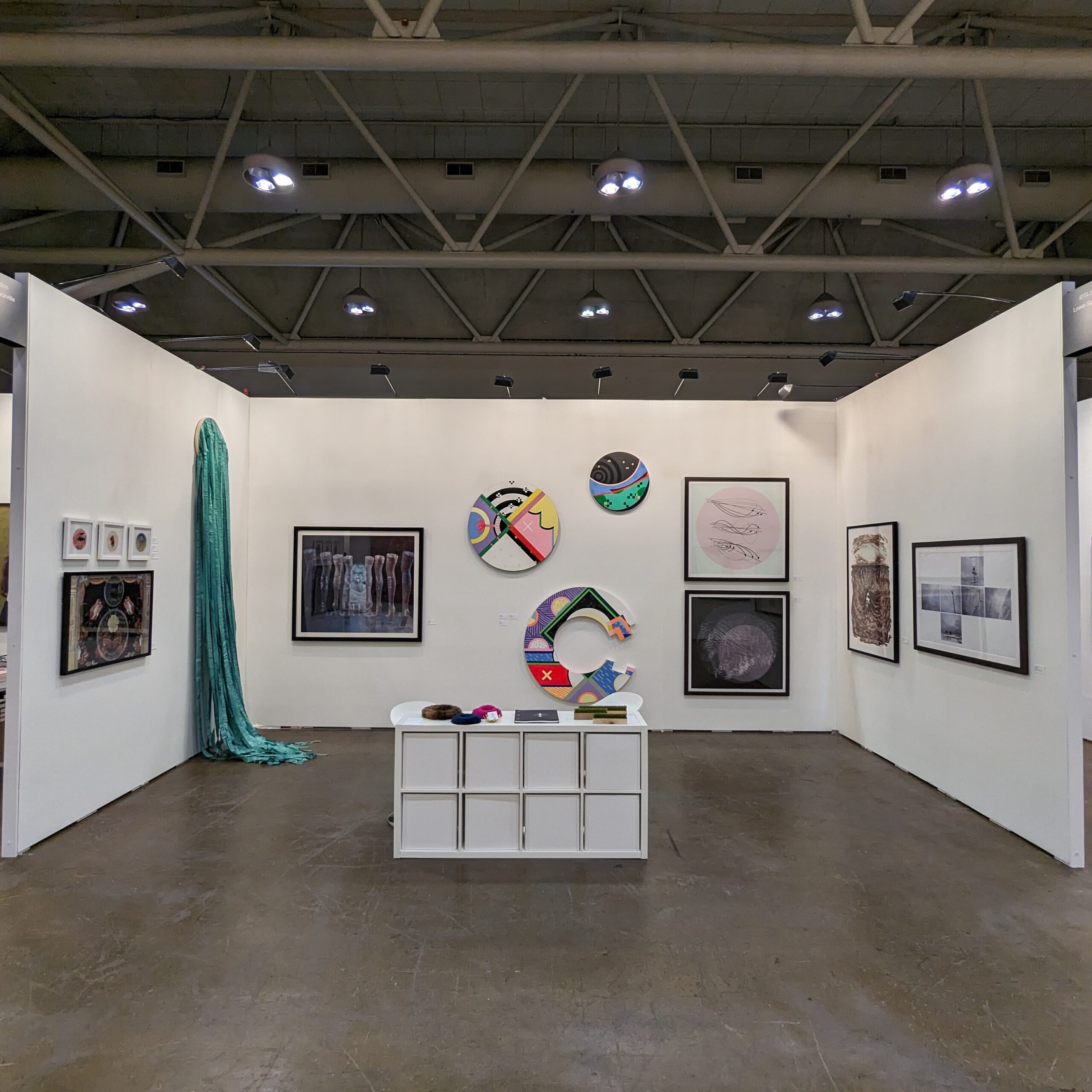 brightly coloured artworks installed in a white art fair booth