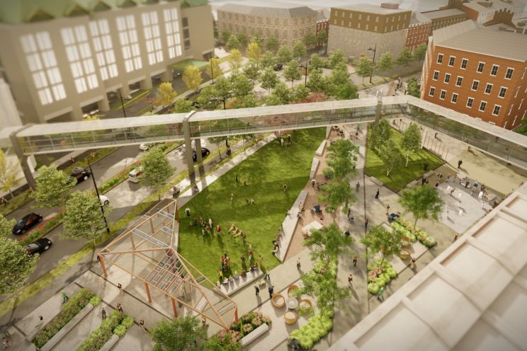 Digitally rendered bird’s eye view of an irregular shaped park in a city centre, at dusk, with an angular pedway stretching overhead. The park is full of people, surrounded by a street with cars, and 5-story buildings. Angular pathways cut through the grassy park, with freestanding rectangular planters, green trees, and a wooden structure with a transparent roof and no walls.